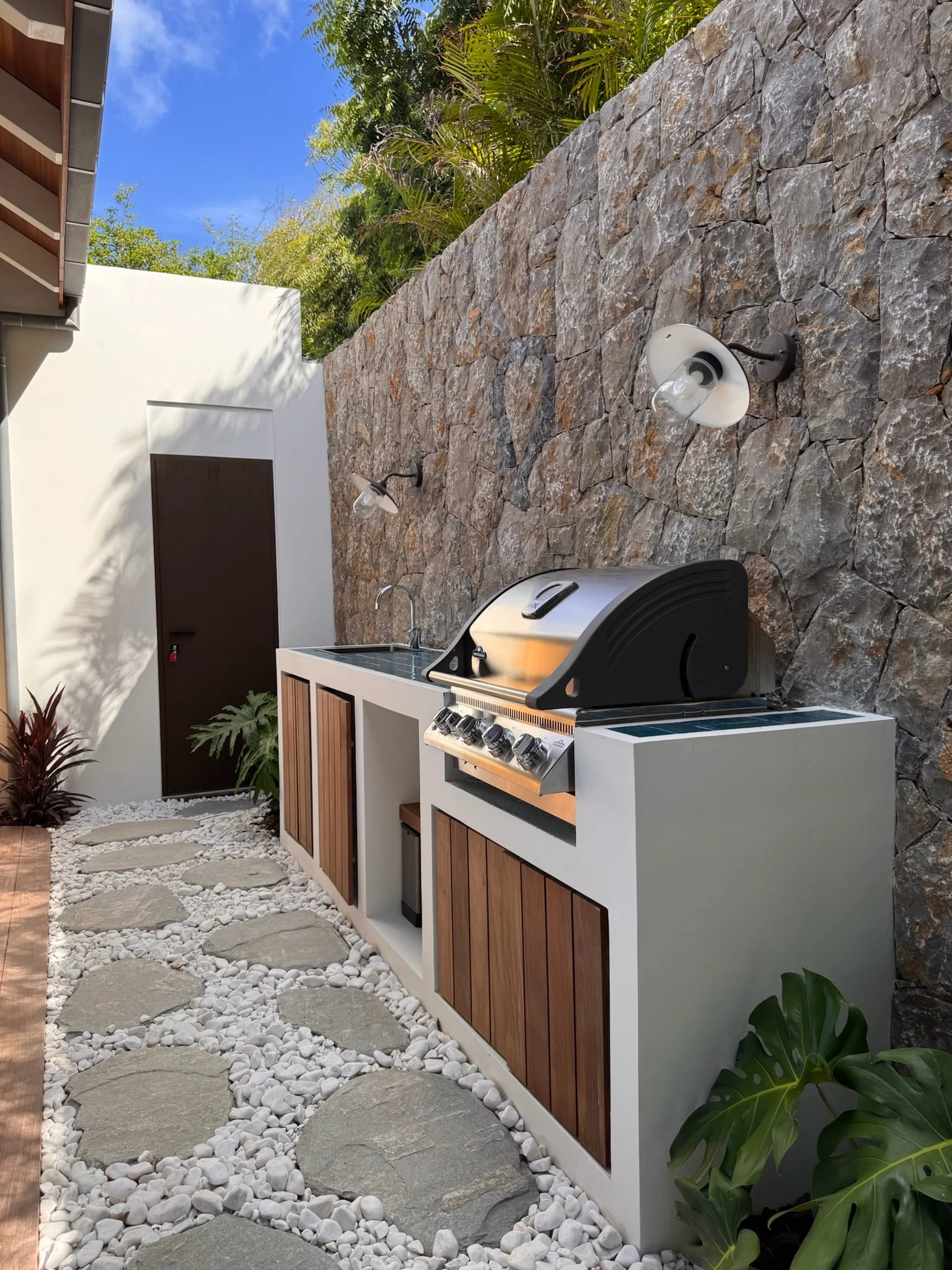 Outdoor kitchen and stepping-stone path along a stone wall — Anse des Cayes
