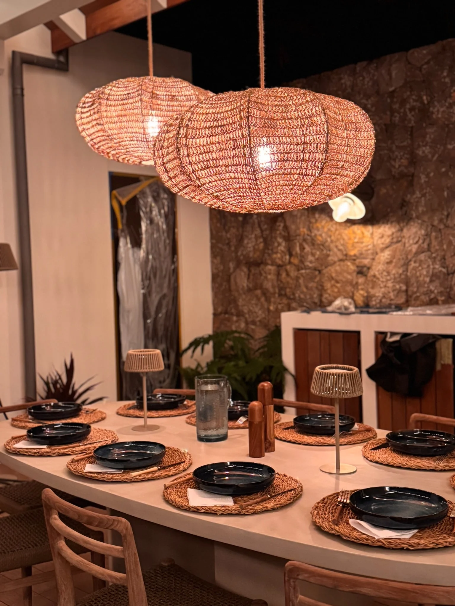 Dining table beneath woven pendant lights — Anse des Cayes
