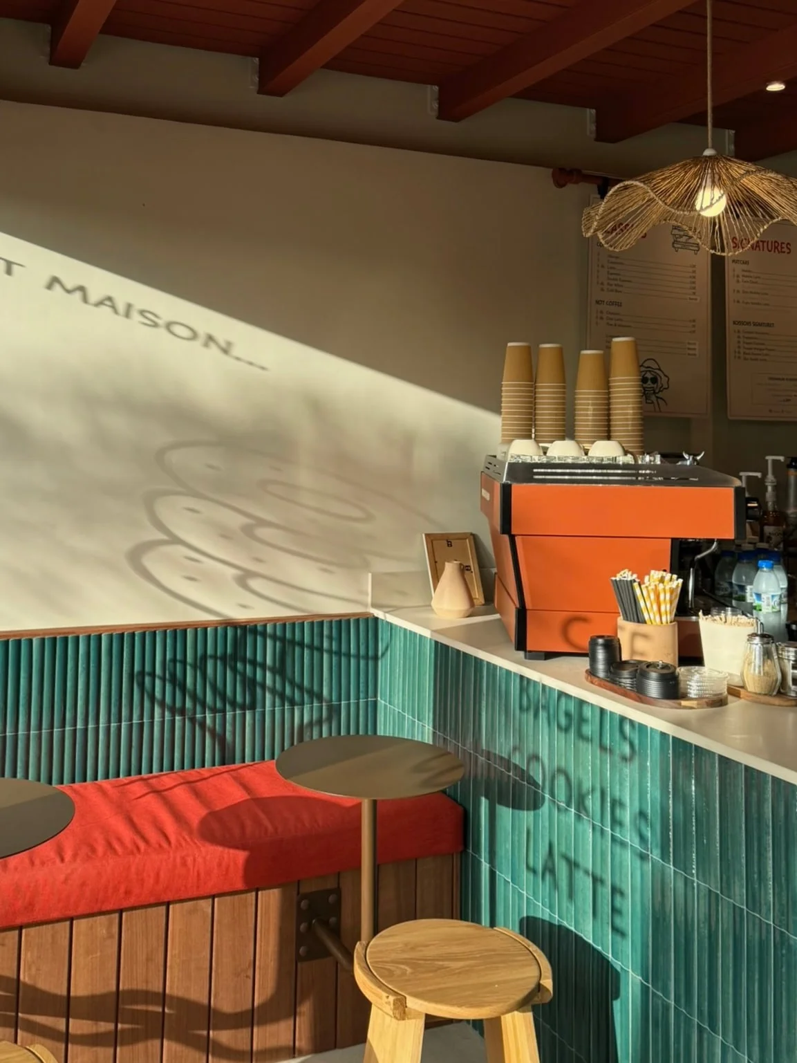 Bench with red cushions alongside the tiled counter — Dado Café