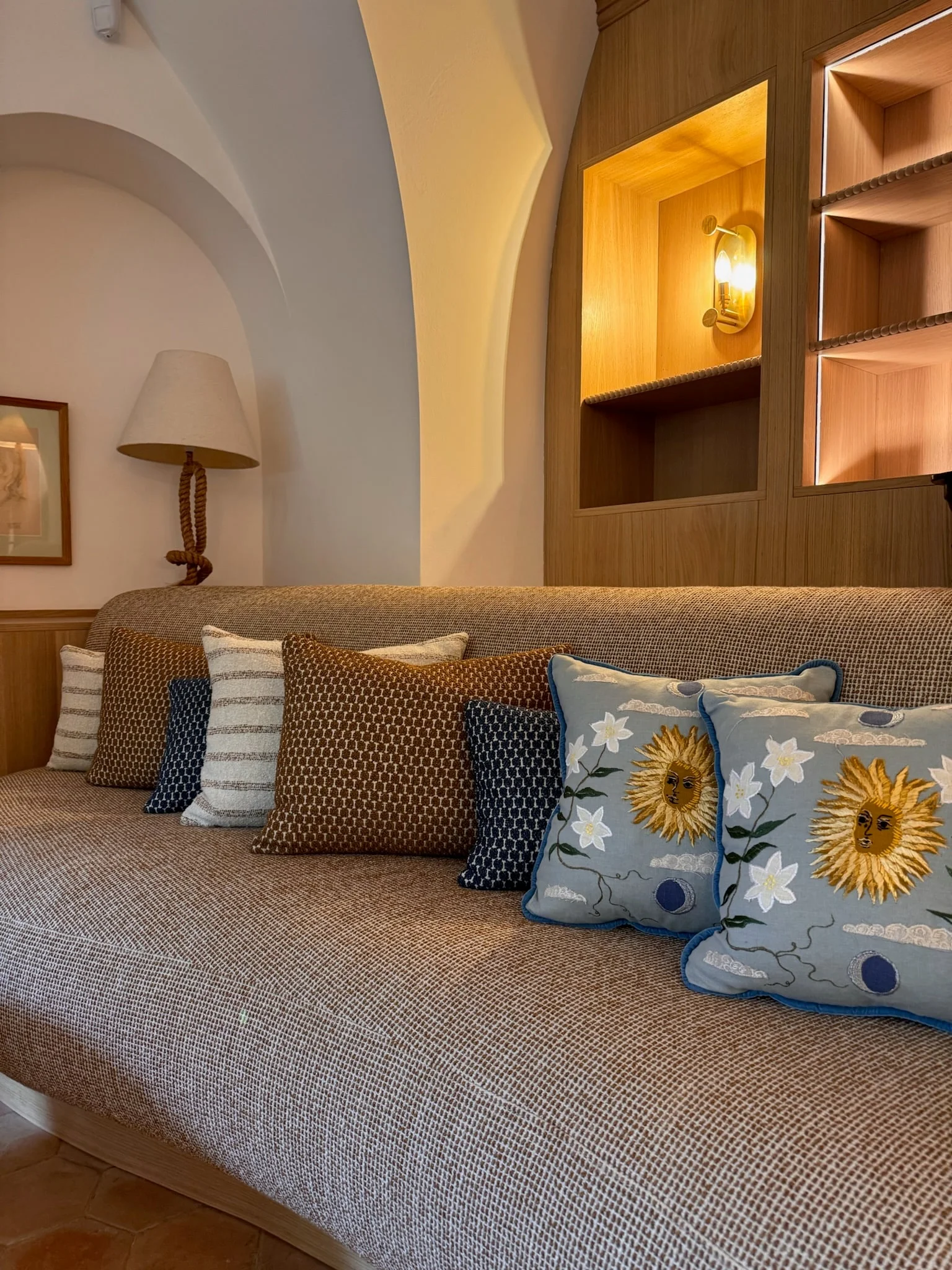 Curved sofa with patterned cushions beneath the vaulted ceiling — Fontaine