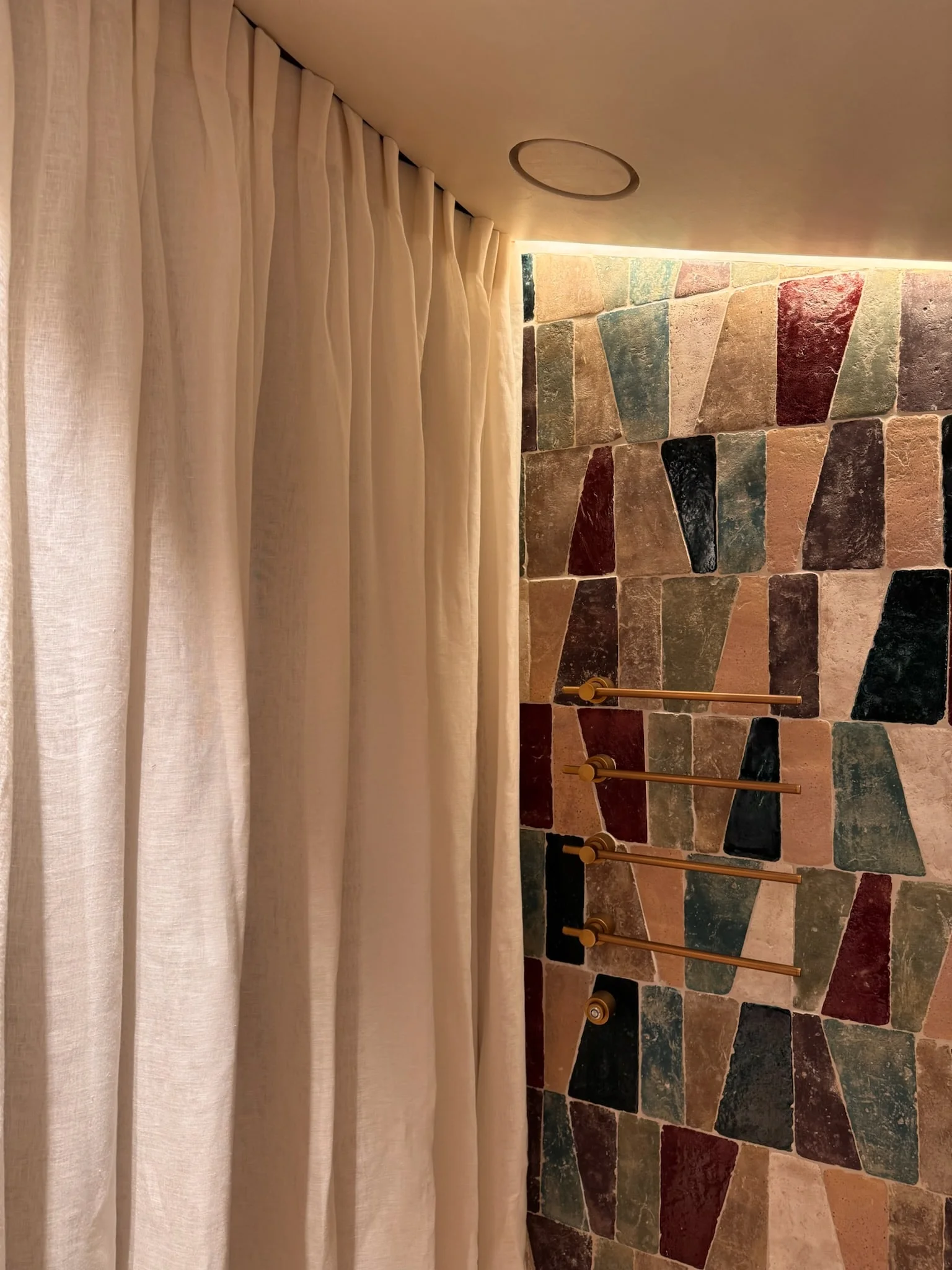 Linen curtain and multicoloured tiled shower wall — Fontaine