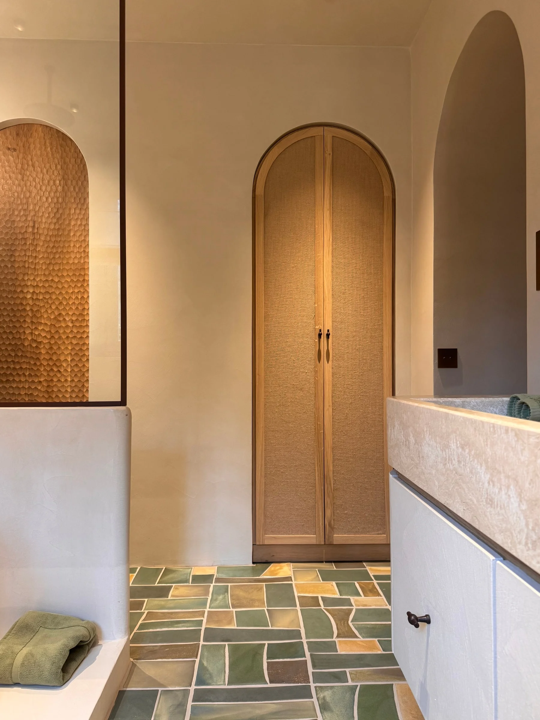 Arched cane door and tiled bathroom floor — Fontaine