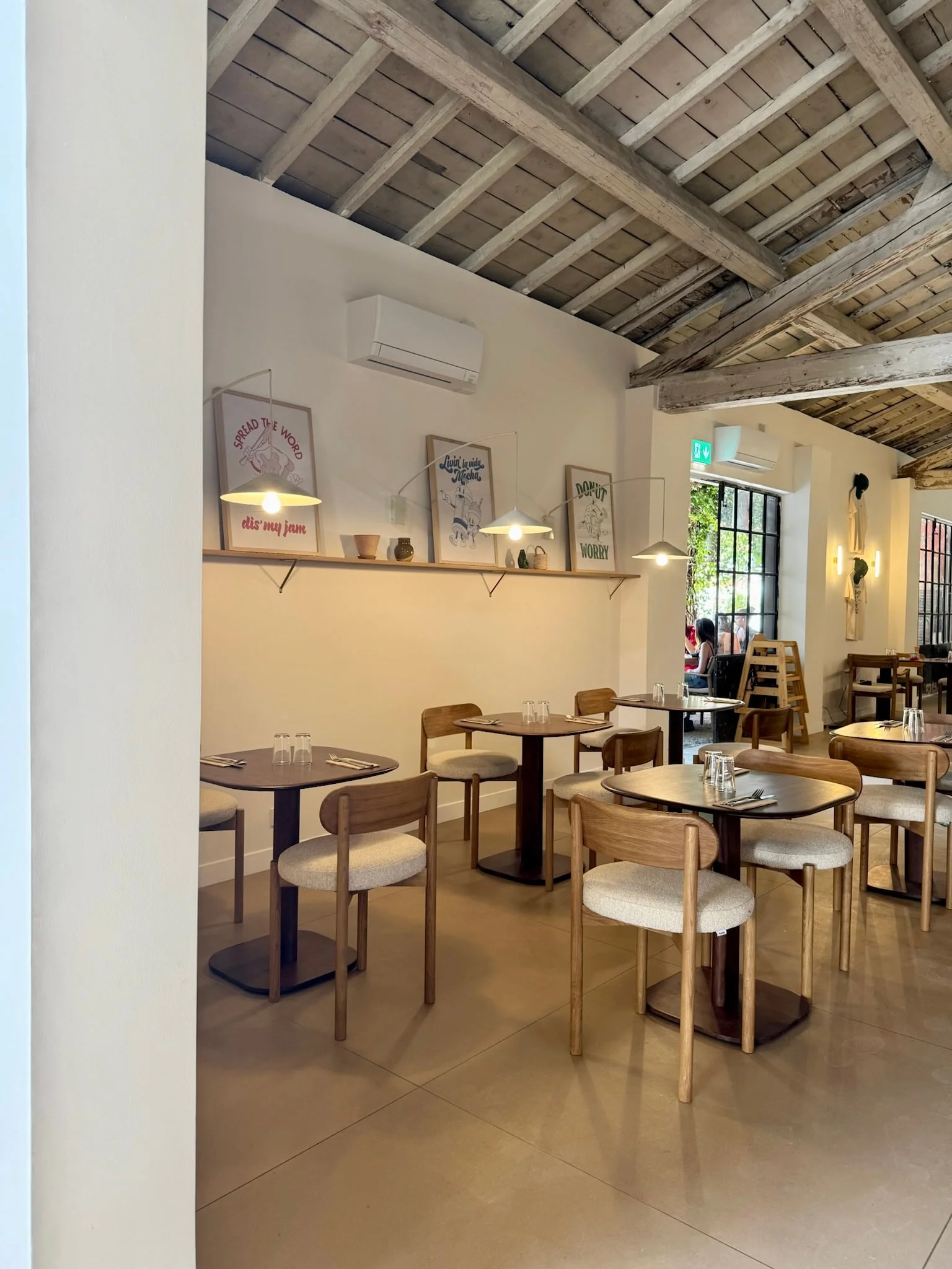 Dining room with round tables and framed pictures — Honoré Brunch