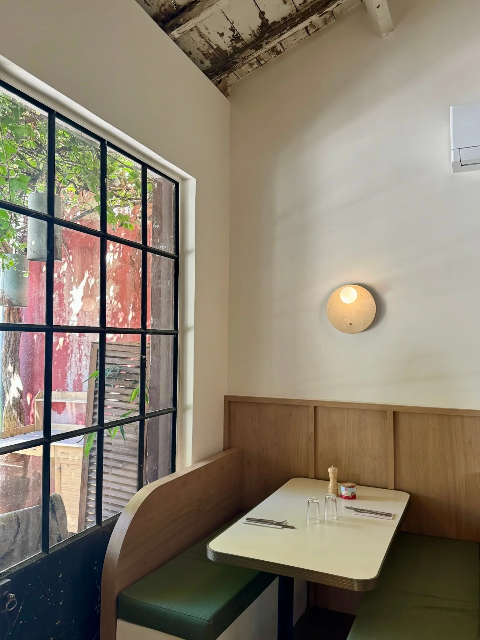 Diner-style booth beside a steel-framed window — Honoré Brunch
