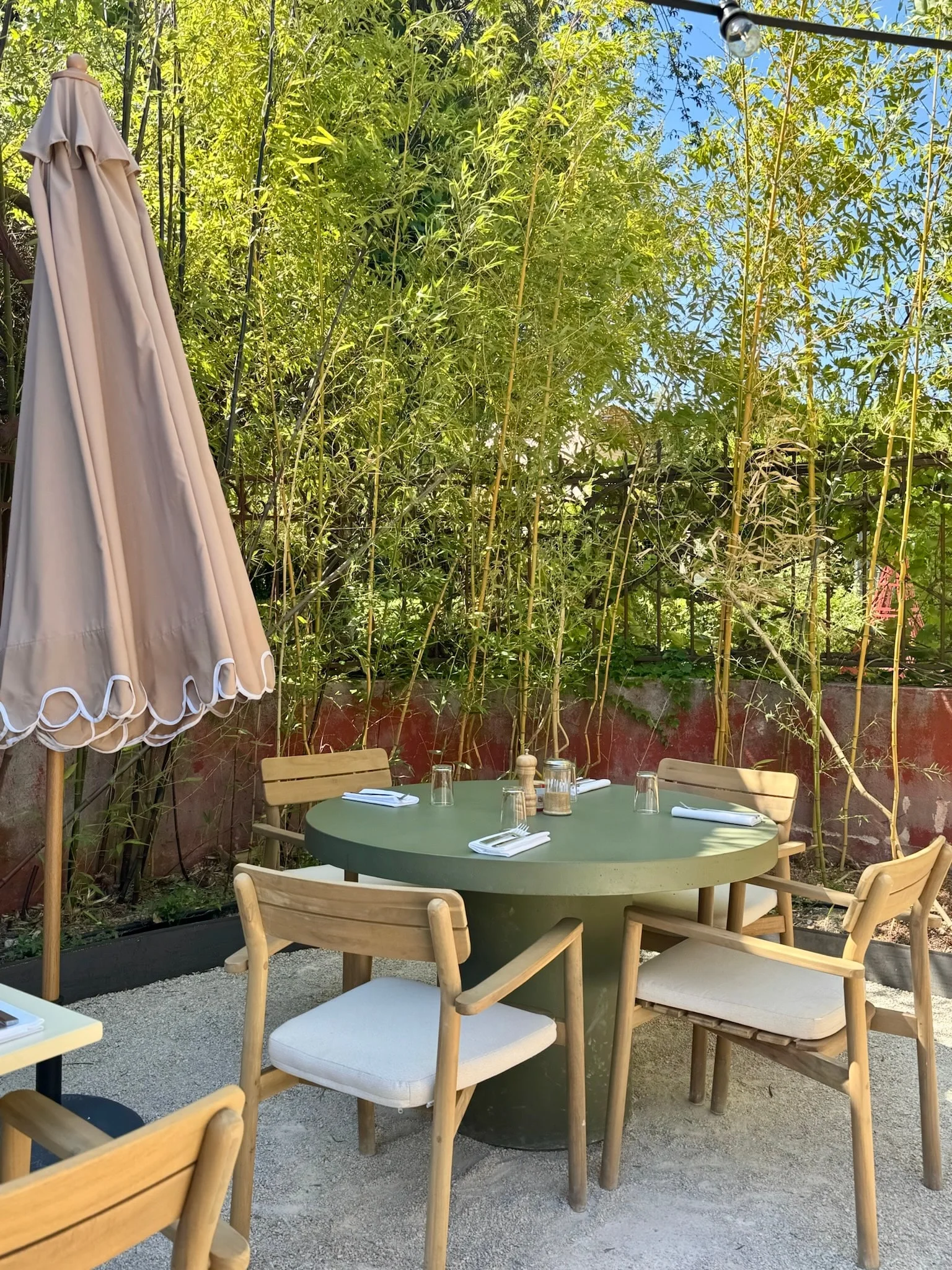 Shaded terrace with a green table among the bamboo — Honoré Brunch