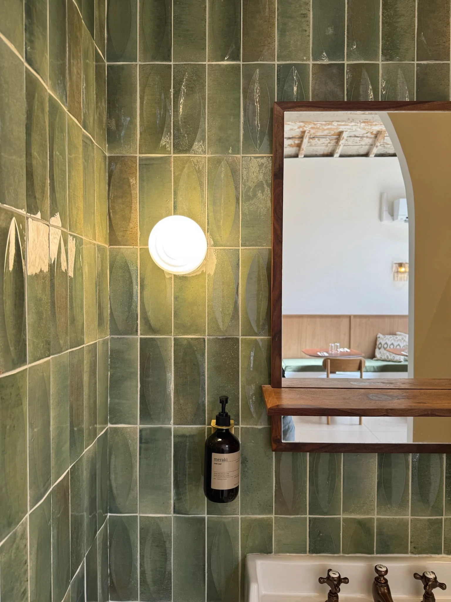 Washroom with green tiles, round wall light and mirror — Honoré Brunch