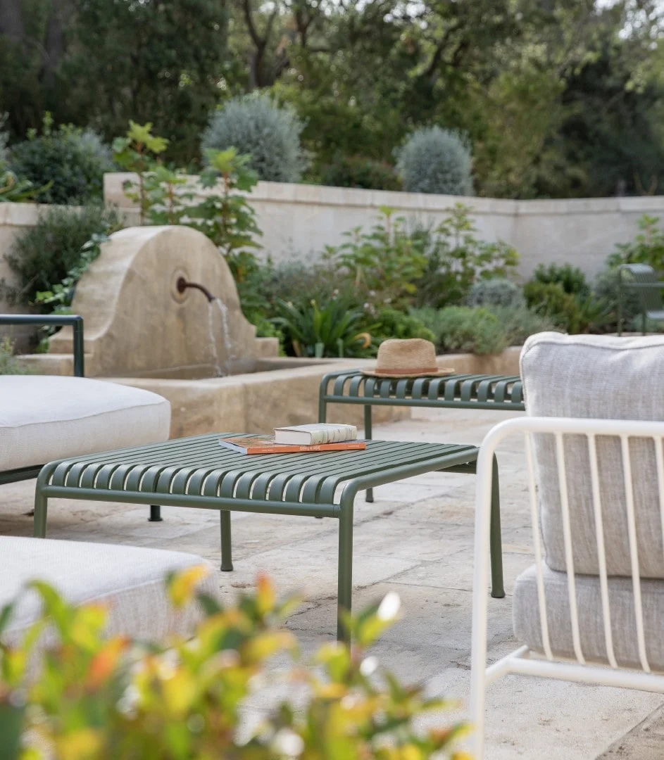 Outdoor lounge beside a stone fountain — Montjoie