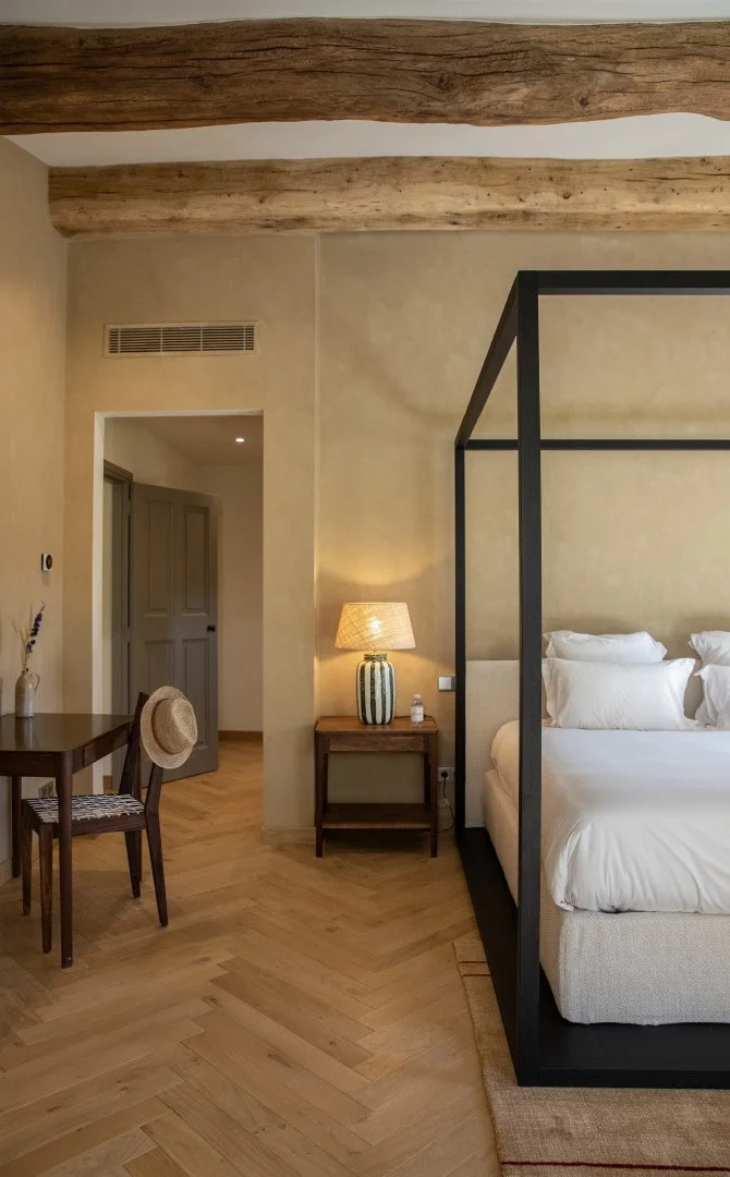 Bedroom with black four-poster bed and herringbone floor — Montjoie