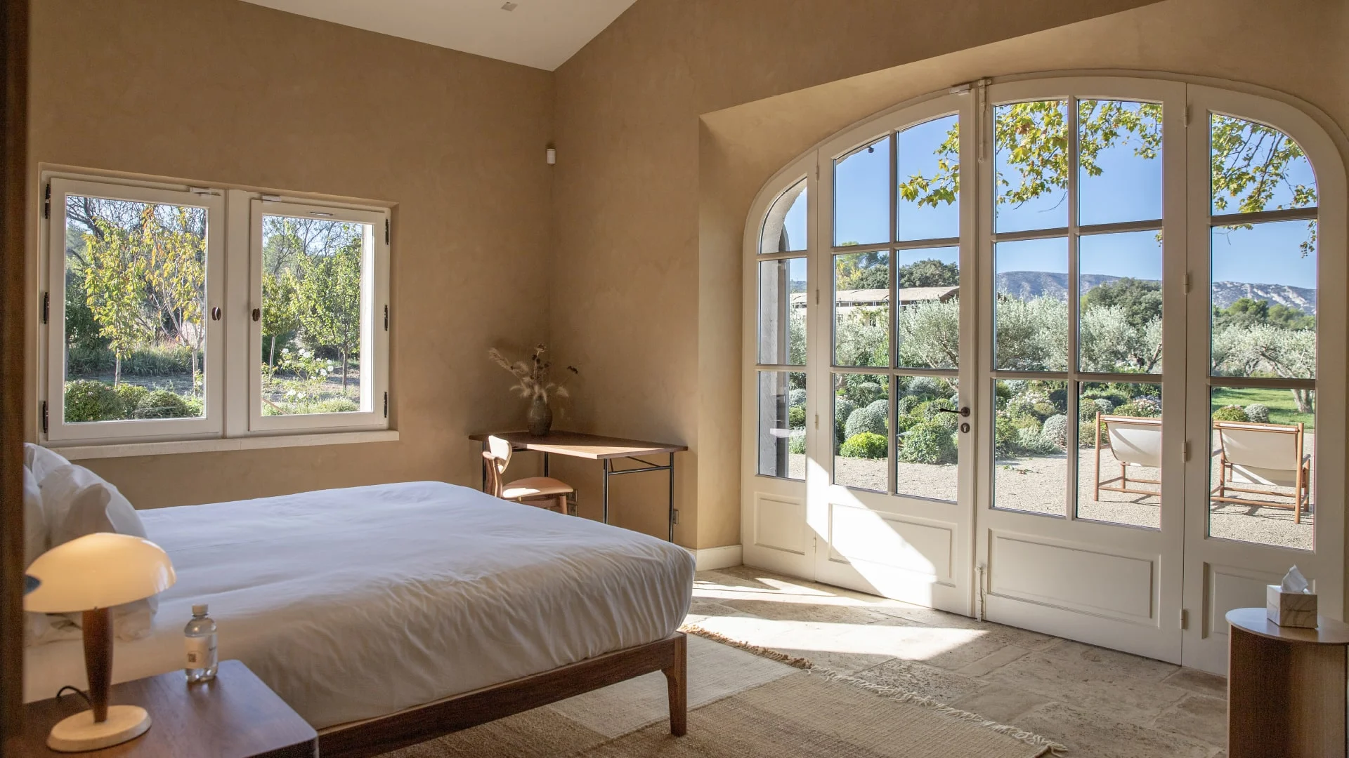 Bedroom with arched French windows onto the garden — Montjoie