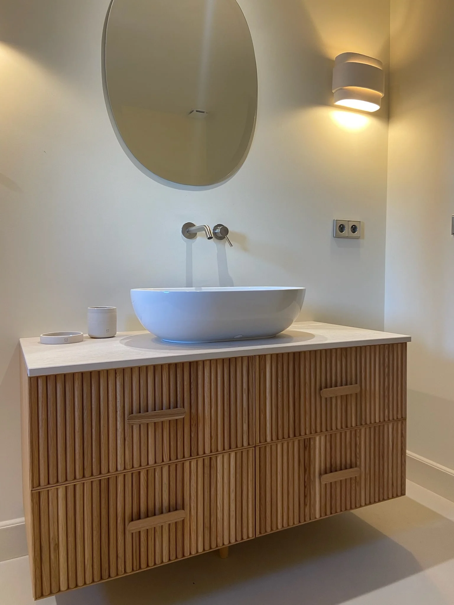 Washbasin on a fluted wooden vanity with oval mirror — Montjoie