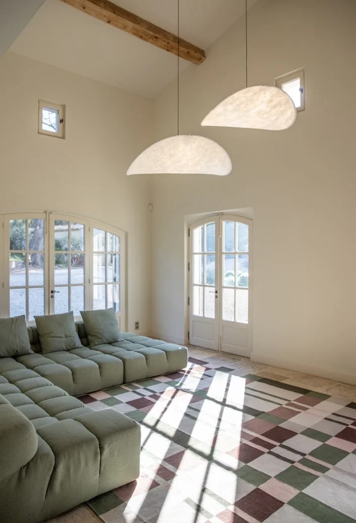 Modular sofa and patterned tiled floor beneath a high ceiling — Montjoie